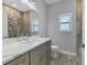 Bathroom featuring updated cabinetry, a large mirror, modern fixtures, and unique tiled walls and flooring at 12534 Mohican Ave, Port Charlotte, FL 33953