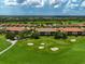 Scenic aerial view of a golf community with sand traps, lush fairways, and beautiful tiled roof homes at 12720 Sorrento Way # 103, Bradenton, FL 34211