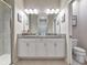 Bathroom featuring a double vanity with white cabinets, granite counters, and glass shower at 12720 Sorrento Way # 103, Bradenton, FL 34211