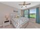Scenic bedroom with a ceiling fan, large windows overlooking greenery, and stylish furnishings at 12720 Sorrento Way # 103, Bradenton, FL 34211