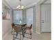 Cozy breakfast nook with a chandelier, table with four chairs, and two windows with designer curtains at 12720 Sorrento Way # 103, Bradenton, FL 34211