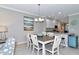Bright dining area with a table for six, modern lighting, and seamless access to the kitchen, perfect for entertaining at 12720 Sorrento Way # 103, Bradenton, FL 34211