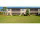 Beautiful back of building with manicured lawn, screened in lanais and patio, offering relaxing outdoor living at 12720 Sorrento Way # 103, Bradenton, FL 34211