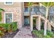 Charming condo entrance with a brick walkway, stone accents, and lush landscaping, creating a welcoming curb appeal at 12720 Sorrento Way # 103, Bradenton, FL 34211