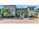 Beautiful condo building featuring lush landscaping, a paver driveway, and elegant architectural details under a bright blue sky at 12720 Sorrento Way # 103, Bradenton, FL 34211