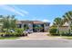 Exterior view of a condo building with a tile roof, meticulous landscaping and paver parking at 12720 Sorrento Way # 103, Bradenton, FL 34211