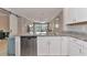 Well-equipped kitchen offering stainless steel appliances, white cabinets, granite countertops, and an open view to the dining area at 12720 Sorrento Way # 103, Bradenton, FL 34211