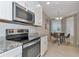 Modern kitchen equipped with stainless steel appliances, granite countertops, and white cabinetry near the dining area at 12720 Sorrento Way # 103, Bradenton, FL 34211