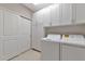 Clean laundry room features a washer, dryer, storage cabinets, and ample space at 12720 Sorrento Way # 103, Bradenton, FL 34211