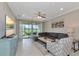 Bright living room with comfortable gray sofa, stylish decor, and a scenic view of the golf course through sliding glass doors at 12720 Sorrento Way # 103, Bradenton, FL 34211