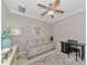 Cozy living room with a couch, ceiling fan, and decorative mirror creating a welcoming space at 12720 Sorrento Way # 103, Bradenton, FL 34211