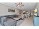 Open-concept living area with a comfortable gray sofa, tile flooring, and a clear view of the dining area and kitchen at 12720 Sorrento Way # 103, Bradenton, FL 34211