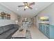 Spacious living area featuring a comfortable gray sofa, modern decor, and a seamless flow to the dining area and kitchen at 12720 Sorrento Way # 103, Bradenton, FL 34211