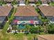 Aerial view of house with red tiled roof, screened pool, lush landscaping and patio seating at 13786 Vancanza Dr, Venice, FL 34293