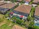 Aerial view of house with red tiled roof, screened pool, lush landscaping and patio seating at 13786 Vancanza Dr, Venice, FL 34293