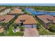 Stunning aerial view of a home near a lake with a tile roof and well-maintained landscaping at 13786 Vancanza Dr, Venice, FL 34293