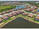 A beautiful aerial view of a lakeside community featuring well-maintained homes and lush greenery at 13786 Vancanza Dr, Venice, FL 34293