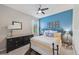 Charming bedroom featuring a wrought iron bed frame, blue accent wall, and decorative wall art at 13786 Vancanza Dr, Venice, FL 34293