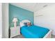 Cozy bedroom featuring a blue accent wall, a white bed, and ample natural light at 13786 Vancanza Dr, Venice, FL 34293