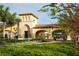 Elegant community entrance with lush landscaping, a grand archway, and stone accents at 13786 Vancanza Dr, Venice, FL 34293