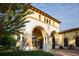 Detailed shot of the community entrance with stone columns, arched windows, and well-kept landscaping at 13786 Vancanza Dr, Venice, FL 34293