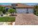 Charming home featuring a brick driveway, well-manicured lawn, and attached two-car garage at 13786 Vancanza Dr, Venice, FL 34293