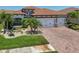 Charming home featuring a brick driveway, well-manicured lawn, and attached two-car garage at 13786 Vancanza Dr, Venice, FL 34293