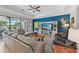 Spacious living room with modern furniture, tray ceilings, and scenic views of the outdoors at 13786 Vancanza Dr, Venice, FL 34293