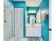 Stylish bathroom with a walk-in shower, bright blue paint, a vanity and a large mirror at 1447 Gleneagles Dr, Venice, FL 34292