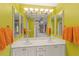 Bathroom featuring double sinks, large vanity mirrors, and bright lime green walls at 1447 Gleneagles Dr, Venice, FL 34292