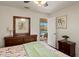 Charming bedroom with a queen-size bed, wood flooring, and serene views of the pool area at 1447 Gleneagles Dr, Venice, FL 34292