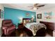 Relaxing bedroom features a queen-size bed, a cozy chair, and dark wood flooring at 1447 Gleneagles Dr, Venice, FL 34292