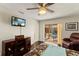 Relaxing bedroom features a TV, a cozy chair, and dark wood flooring overlooking a pool area at 1447 Gleneagles Dr, Venice, FL 34292