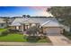 Beautiful home with a well-manicured lawn, tile roof, mature trees, and an attached two car garage at 1447 Gleneagles Dr, Venice, FL 34292