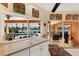 Kitchen view of the pool through the window and sliding glass doors to the lanai at 1447 Gleneagles Dr, Venice, FL 34292