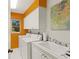 Bright laundry room features white cabinets, tile flooring, a window, and a sink at 1447 Gleneagles Dr, Venice, FL 34292
