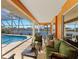 Covered lanai area with a pool, multiple seating arrangements, and views of the lake at 1447 Gleneagles Dr, Venice, FL 34292