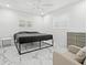 Modern bedroom with marble floors, a platform bed, and windows with natural light; includes a comfortable chair at 172 Sea Anchor Dr, Osprey, FL 34229