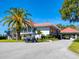 Spacious clubhouse featuring a red tile roof, a golf cart, and lush landscaping, welcoming residents and guests at 172 Sea Anchor Dr, Osprey, FL 34229