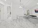 Bright dining room featuring a glass table, transparent chairs, and white marble floors at 172 Sea Anchor Dr, Osprey, FL 34229