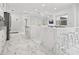 Spacious white kitchen featuring marble countertops, recessed lighting, and modern bar stool seating at 172 Sea Anchor Dr, Osprey, FL 34229