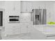 Bright kitchen boasts white cabinetry, stainless steel appliances, and luxurious marble countertops at 172 Sea Anchor Dr, Osprey, FL 34229