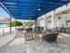 Inviting outdoor lounge area with comfortable seating, ceiling fans, and a stylish blue pergola at 172 Sea Anchor Dr, Osprey, FL 34229
