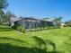 Beautiful screened pool area with lush green landscaping, patio, and white tile roof home at 172 Sea Anchor Dr, Osprey, FL 34229