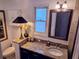 Bathroom with granite counters, modern vanity, decorative mirror and a decorative light fixture at 173 Bath Club N Blvd, North Redington Beach, FL 33708