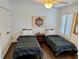 Inviting bedroom featuring wood floors, a ceiling fan, and two twin beds for guests at 173 Bath Club N Blvd, North Redington Beach, FL 33708