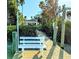 Inviting dock featuring a white bench, clear view of the waterfront, and tropical foliage at 173 Bath Club N Blvd, North Redington Beach, FL 33708