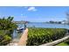 Beautiful waterfront view with a private dock and boat under a clear blue sky at 173 Bath Club N Blvd, North Redington Beach, FL 33708