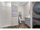 Modern bathroom boasts tiled shower, gray vanity, stylish mirror, and stacked washer dryer at 19006 69Th E Ave, Bradenton, FL 34211