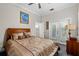 This bedroom features an elegant bed, ensuite access, and balcony doors with plantation shutters at 19006 69Th E Ave, Bradenton, FL 34211